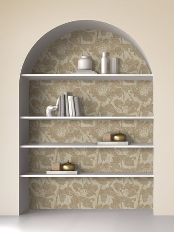 Arched shelving niche backed with beige floral peel and stick wallpaper, styled with books, vases and brass objects