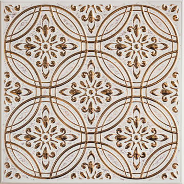 A single square peel and stick metal tile photographed straight on, its raised gold pattern of interlocking circles and fleur-de-lis motifs catching the light against a distressed off-white ground.