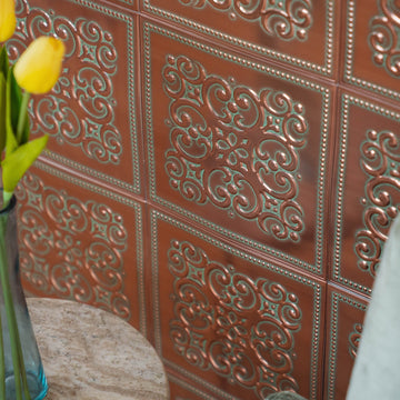 Patina Copper peel and stick metal tiles installed over a wall as a kitchen backsplash, with yellow tulips on the counter