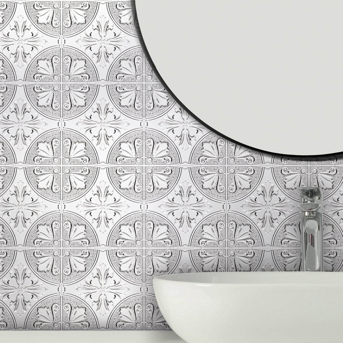 Silver Fleur embossed metal tiles on a bathroom wall behind a white vessel basin with a chrome faucet and a round black-rimmed mirror