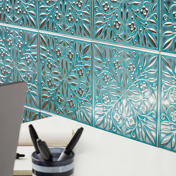Teal and Silver Leaves peel and stick metal tiles installed on a wall above a desk workspace