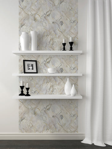 A single vertical run of marble-print peel and stick wallpaper on a white painted wall behind three white floating shelves styled with white vases, a framed photo and black candlesticks
